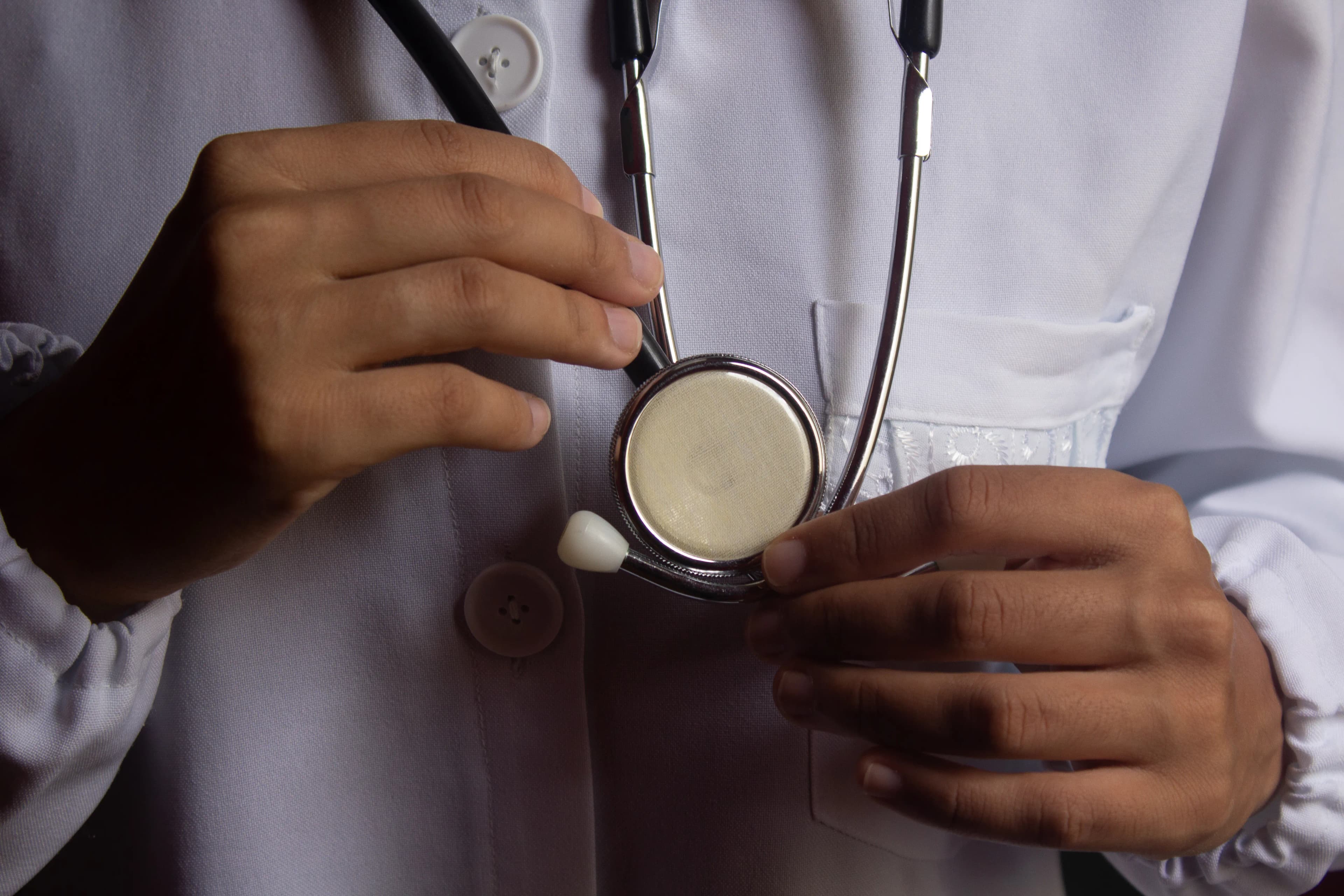 A doctor holding a stethoscope in close-up.